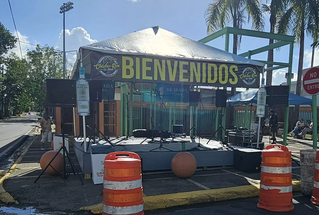 Escenario montado en la calle para una actividad comunitaria con banner de bienvenida